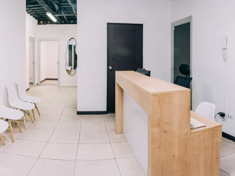 Recepción de Mood Clinic San Salvador, con mostrador de madera y sala de espera