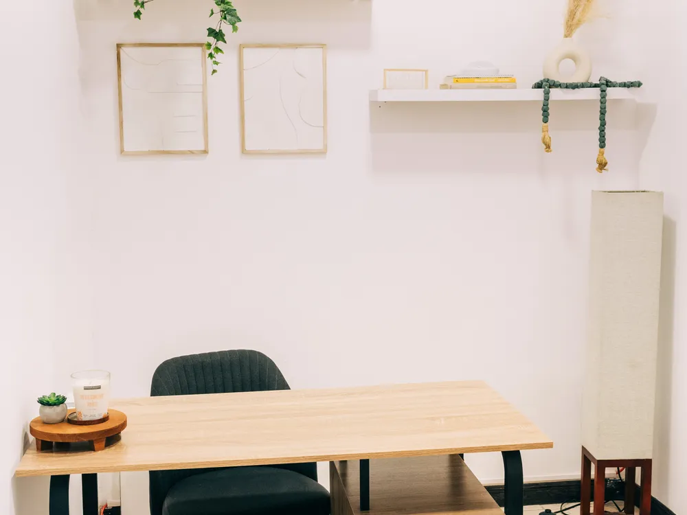 Espacio de trabajo de Mood Clinic San Salvador con mesa de madera y cuadros