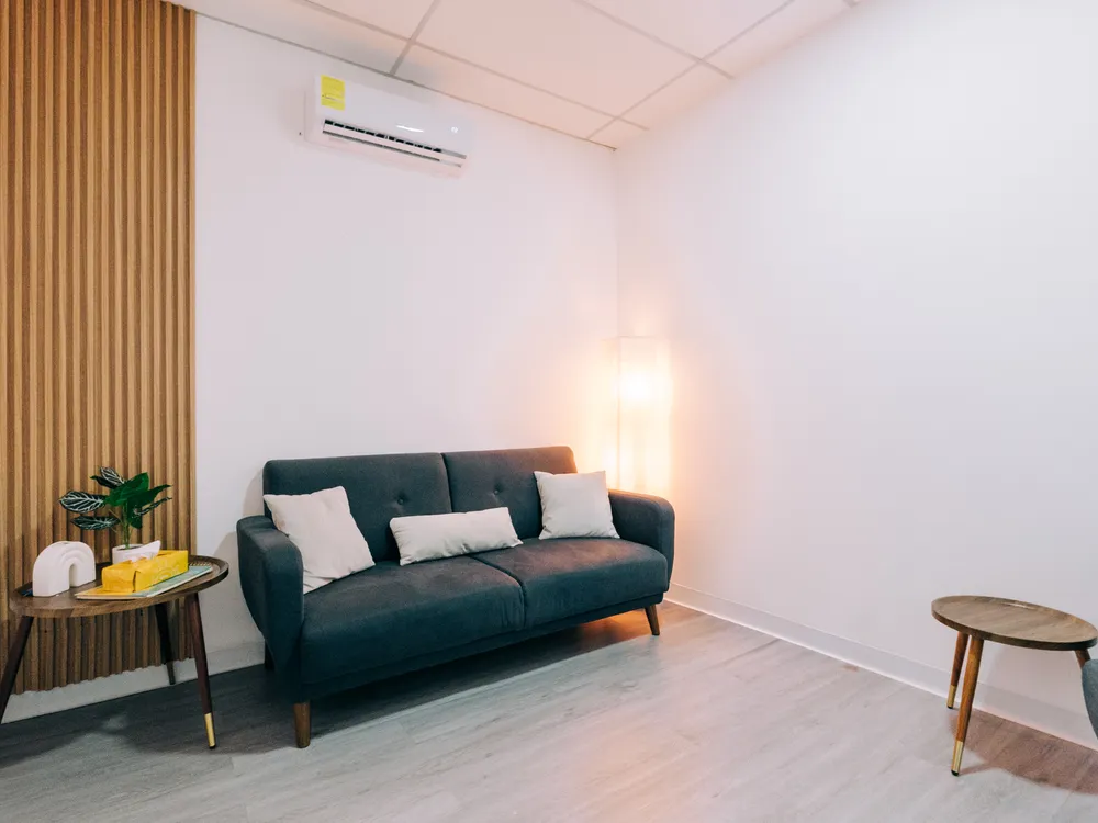 Consultorio de Mood Clinic Santa Ana con sofá, lámpara cálida y panel de madera