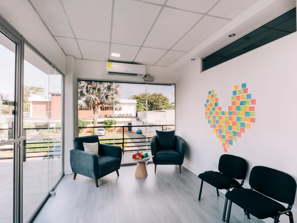 Sala de espera de Mood Clinic Santa Ana, con ventanal al exterior y un corazón hecho de notas de colores
