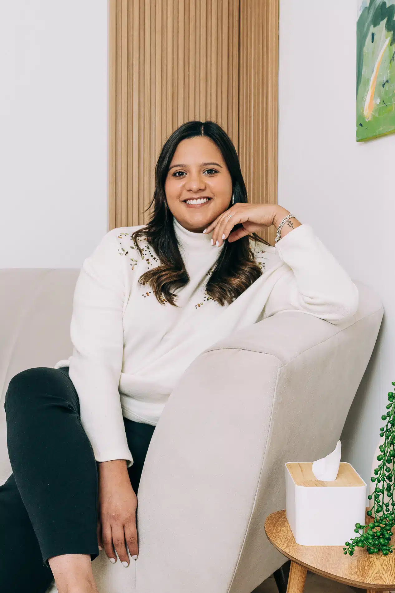 Psicóloga en San Salvador sentada en un sillón durante una sesión en Mood Clinic, mostrando una expresión cálida y profesional.